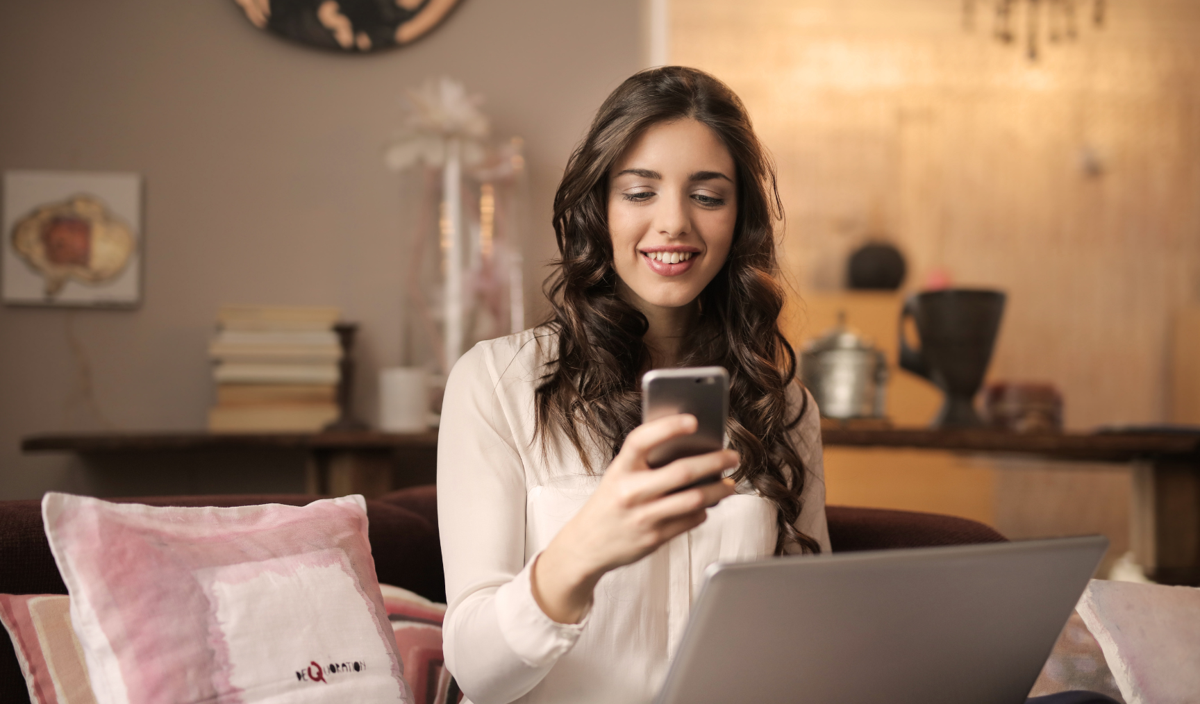 Woman looks at her phone smiling in an office
